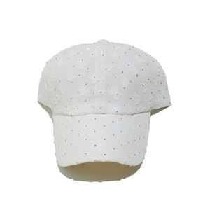 Detailansicht der weißen Baseballkappe mit 3D-Blumenstruktur und funkelnden Strasssteinen