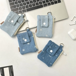 Macro detail of denim fabric card holders with metal hooks and snap closure on desk
