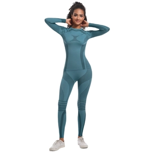 Women's teal seamless yoga set featuring long sleeve crop top and high waist leggings