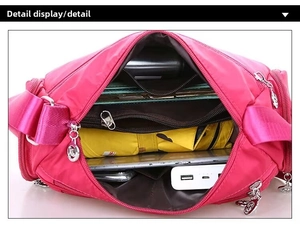 Vista interna di una borsa a tracolla in nylon rosa con diversi scomparti per l'organizzazione