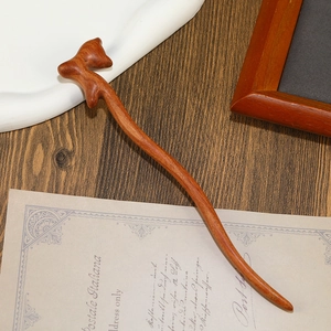 Macro detail of hand-carved sandalwood hair stick featuring a red-brown fox topper