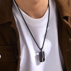 Men's stylish black stainless steel dog tag necklace with ripple texture on a male model