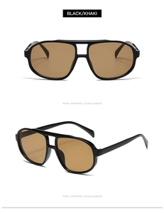 Detail of oversized aviator sunglasses with black thick frames and khaki lenses