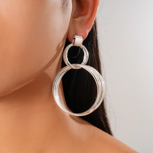 Side view of model wearing silver multi-layer geometric circular layered metal earrings