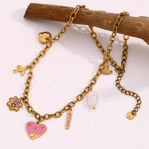 Detail of 18K gold plated chain necklace with pink heart and Amour charm on wood stand