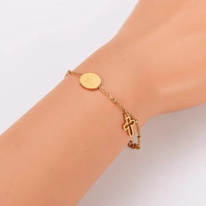 Minimalist gold-plated hollow cross and saint medal bracelet shown on model