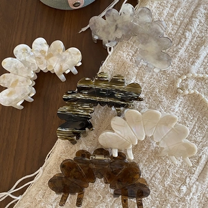 Detail showing five acetic acid flower petal hair claws in assorted marble patterns