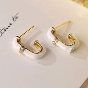 Elegante J-förmige Ohrstecker aus weißem Emaille und Gold mit funkelnden Zirkonia-Steinen