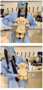 Detailed view of plush toy puppy backpack with yellow dress and lace collar trim