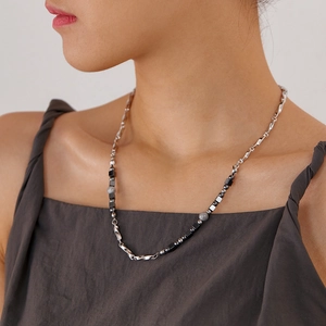 Detail of beaded titanium steel necklace with black geometric stones on neck
