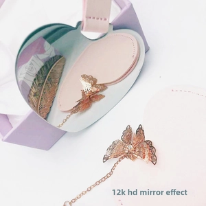 Detail of heart-shaped stainless steel mirror with gold butterfly and pink strap in gift box