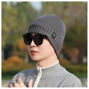 Detailed view of dark grey knitted beanie featuring thick ribbed texture and brand tag