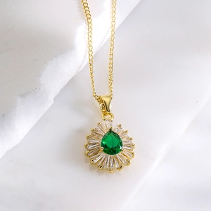 Elegant gold plated sunflower necklace with green teardrop zircon on white marble