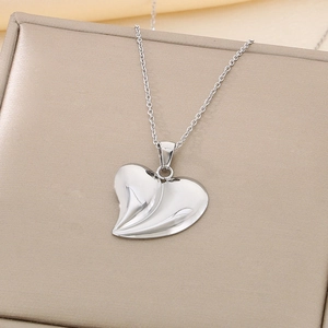 Close-up of a silver 3D heart pendant with textured ripples on a stainless steel chain