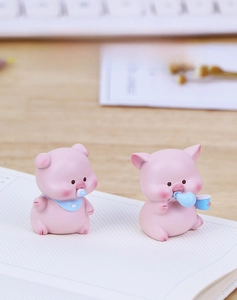 Detail view of cute pink piggy figurines for car dashboard and desk decoration