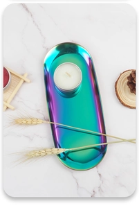 Vertical top view of a rainbow oval metal tray on white marble with dried wheat and pine cones