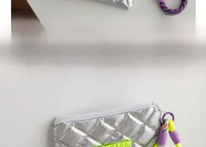 Macro detail of silver quilted PU cosmetic bag with metallic finish and colorful zipper cord
