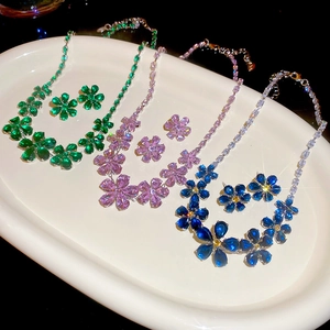 Detailed view of flower jewelry sets with zircon stones in emerald, purple and blue