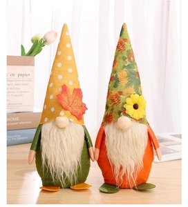Detail of harvest festival gnomes with maple leaf and sunflower on cozy home background
