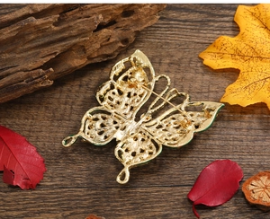 Détail macro d'une broche papillon vintage dorée sur un fond en bois rustique naturel