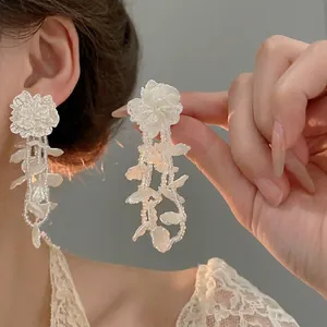 Elegant white floral tassel earrings with pearl bead strands for a graceful feminine look