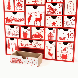 Detail of wooden Christmas advent calendar with numbered drawers and festive red patterns