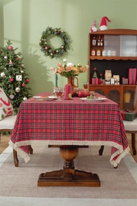 Dettaglio della tovaglia natalizia a quadri rossi con eleganti decorazioni a nappe beige