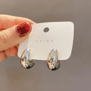 Detailed view of silver water drop earrings with a sleek liquid metal mirror finish