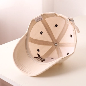 Close-up of beige cotton baseball cap interior with quality stitching and metal buckle