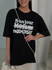 Close-up of black cotton T-shirt featuring white letter print and pearl strap detail