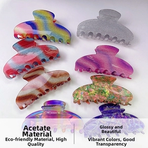 Flat lay of eight colorful acetate hair claws including gradient and marbled star patterns