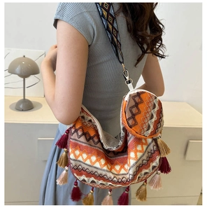 Detailed shot of ethnic knit tote bag with colorful tassels and jacquard shoulder strap