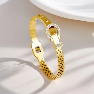 Detailed macro view of 18K gold plated bangle featuring a horseshoe buckle with white zircons