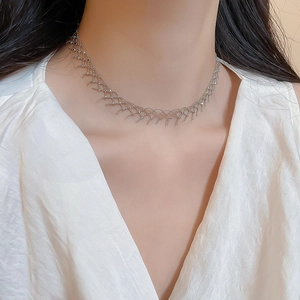 Detailed close-up of silver mesh collar necklace with fringe on model neck