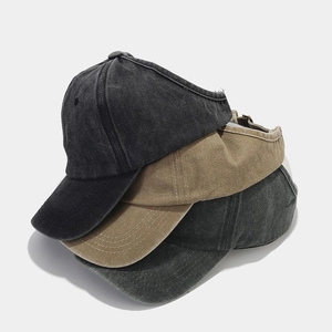 Detailed stack of vintage washed cotton ponytail sun visors in black and khaki colors