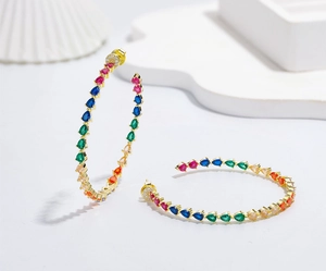 Detail of gold-plated hoop earrings featuring multi-color pear-cut stones in a rainbow pattern