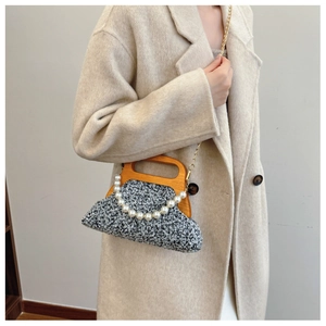 Detail of grey wool-blend bag with wooden handle and elegant pearl chain accessory