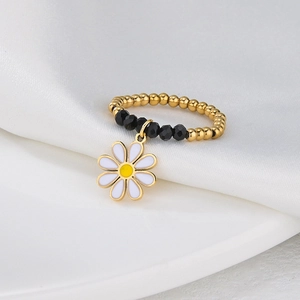 Beaded elastic ring with gold and black beads featuring a white daisy flower charm