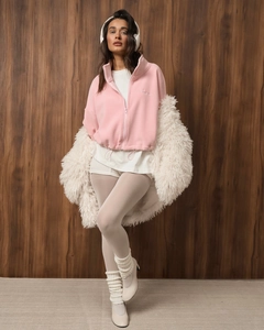 Detail of pink fleece jacket showing embroidery and soft texture in a stylish outfit