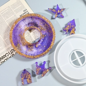 Macro view of silicone mold for resin casting with purple and gold angel house pieces