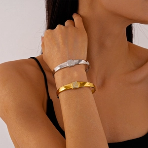 Polished geometric gold and silver bangles with pave-set diamond accents on wrists