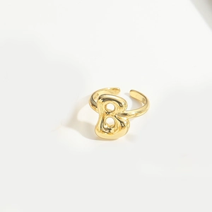 Detailed macro view of a polished gold letter B open ring with balloon style design