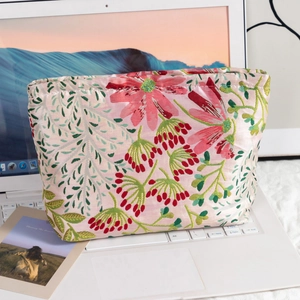 Close-up of pink jacquard floral makeup bag with elegant brocade fabric texture