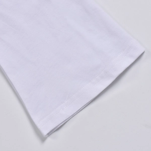 Détail en gros plan de l'ourlet à double couture sur un haut en maille blanc