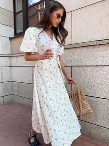 Detail of white wrap maxi dress with yellow floral print and puffed short sleeves