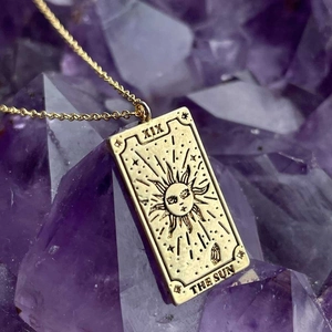 Golden stainless steel tarot card necklace featuring The Sun design with XIX engraving