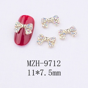 Vue macro détaillée de bijoux d'ongles nœuds dorés avec cristaux AB, taille 11x7,5 mm