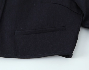 Close-up detail of navy blue blazer pocket with premium twill texture and stitching