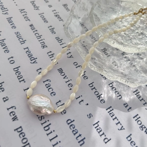 Baroque freshwater pearl necklace with gold beads on textured glass tray