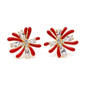 Elegant gold flower earrings with red enamel petals and zircon crystals on white background